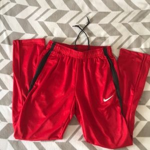 Small red (with 2 black stripes) nike track pants.